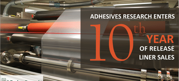 Adhesives Research celebrates 10th year of release liner sales with machinery background.