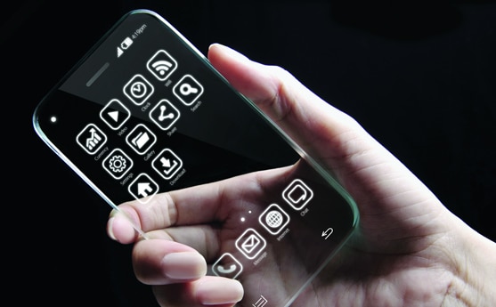Person holding a transparent smartphone with app icons on the screen.