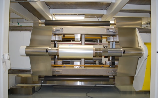 Industrial machinery with metal components and rollers in a factory setting.