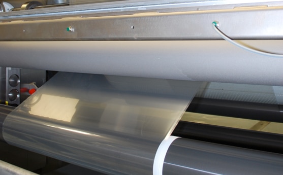 Machine processing transparent film in a factory setting