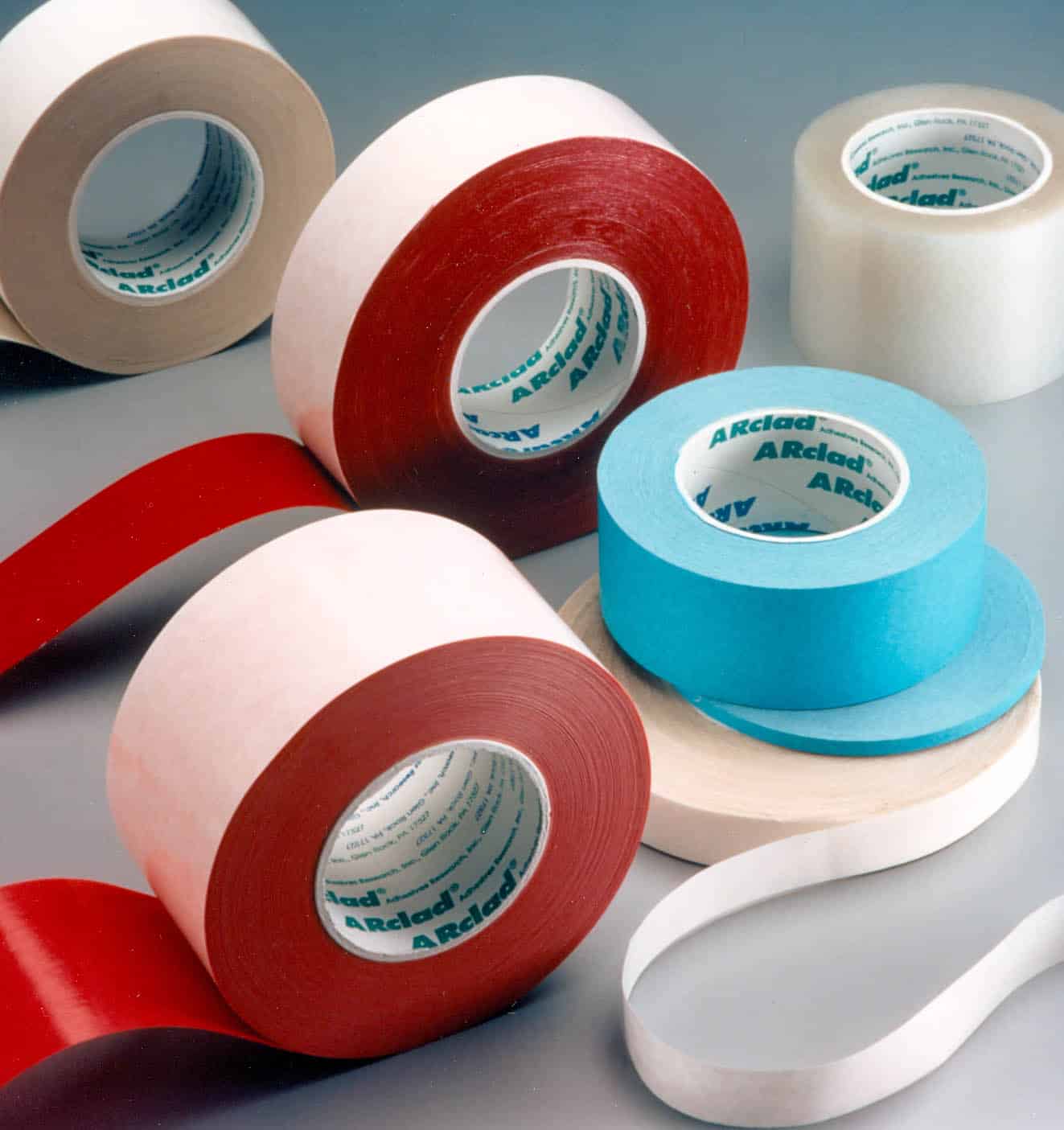 Various colored rolls of adhesive tape on a surface.