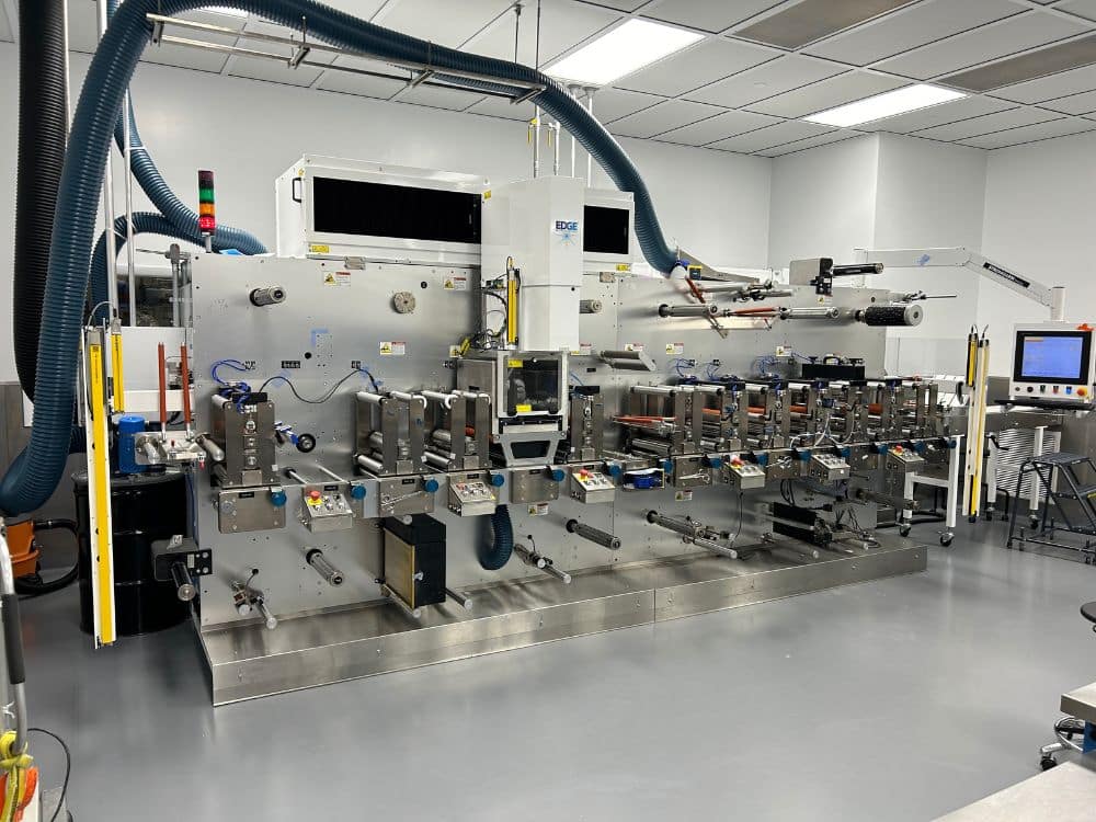Industrial machine in the Adhesives Research factory with various control panels.